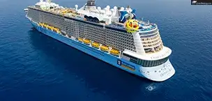 Odyssey of the Seas, anchored in a calm blue ocean. The ship has a blue and yellow color scheme