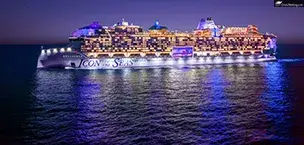 The Icon of the Seas cruise ship at night, illuminated with colorful lights against a starry sky.