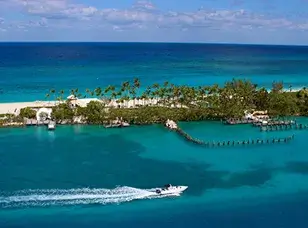 Aerial view of a tropical island with white sandy beaches, turquoise water, and lush green vegetation.