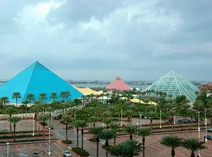 An aerial view of Moody Gardens in Galveston, Texas. The image shows the distinctive pyramid-shaped structures, lush green spaces, and a man-made lagoon.