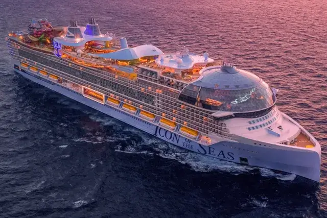 Aerial sunset view of the Icon of the Seas sailing toward the camera