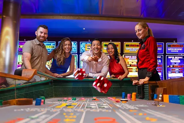 Icon of the Seas, casino, group of players throwing dice at the table in Casino Royale, an attendant at the side, fun, excitement, action, nightlife, games, craps