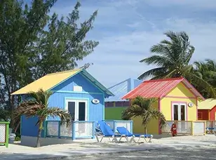 Princess Cays, a private island in the Bahamas, with white sandy beaches, crystal-clear turquoise water, and lush green vegetation.